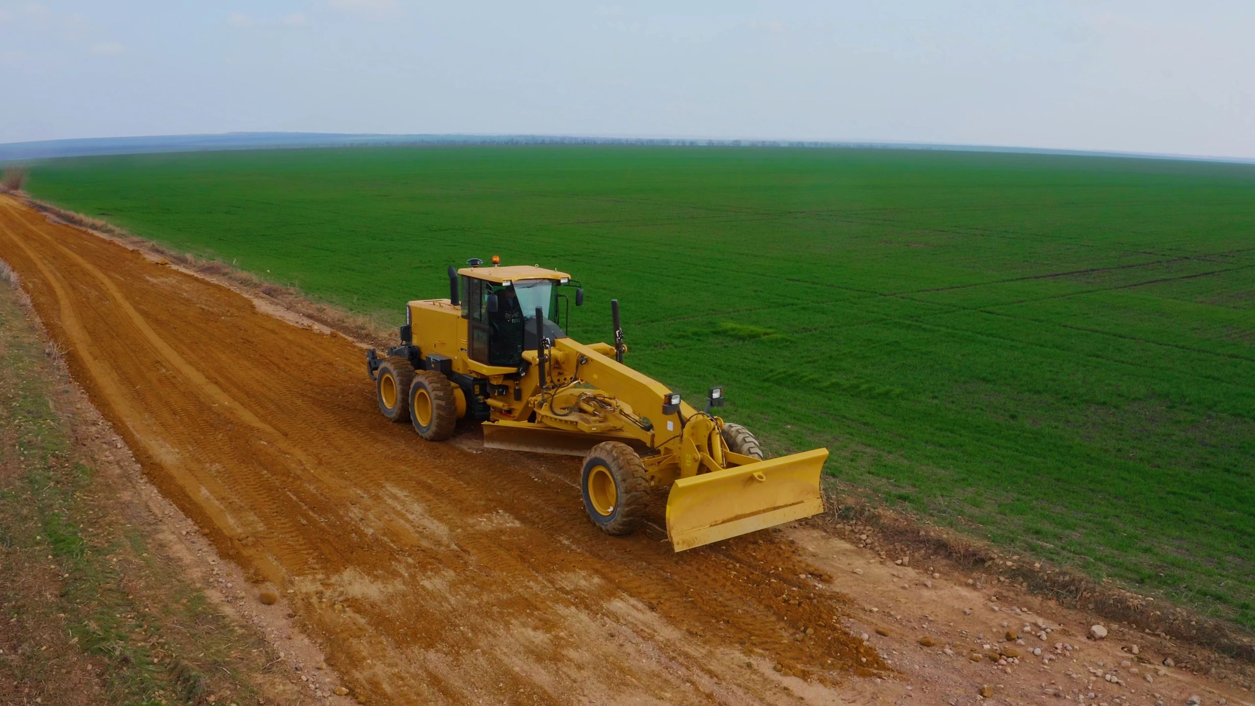 Heavy equipment grader working on a dirt road project